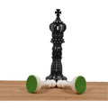 Hand-carved black camel bone king chess piece with green felt base.