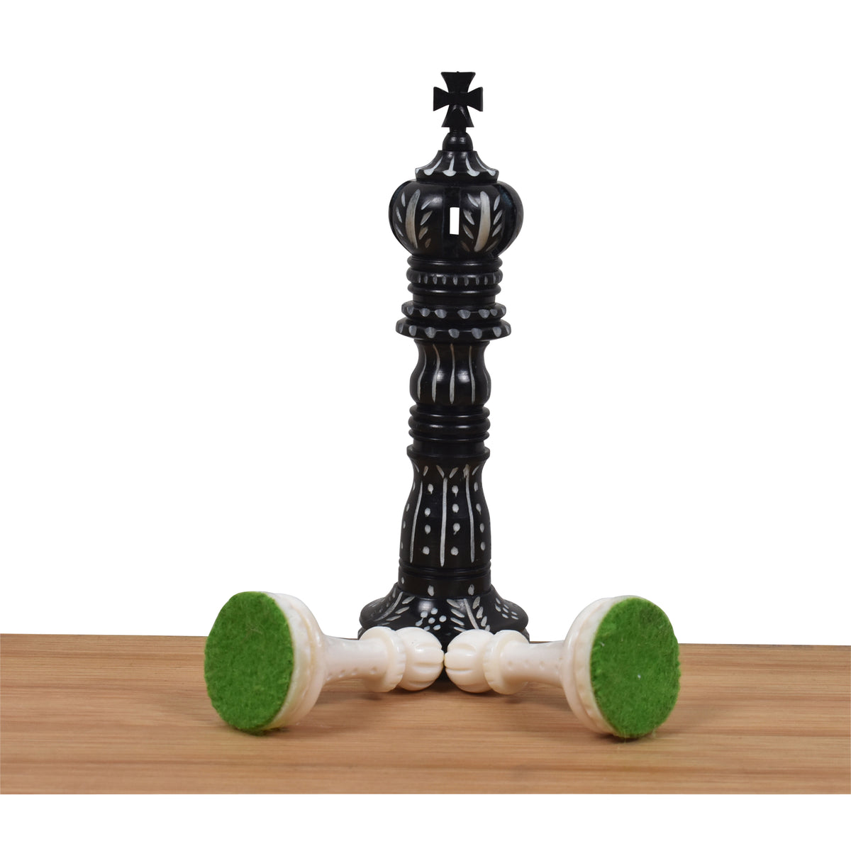 Hand-carved black camel bone king chess piece with green felt base.
