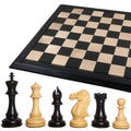 Six luxury Staunton ebony and boxwood chess pieces standing before a 25-inch Drueke style board.