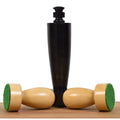 Berliner minimalist ebonised boxwood king piece standing behind two natural boxwood pawns with green felt bases.