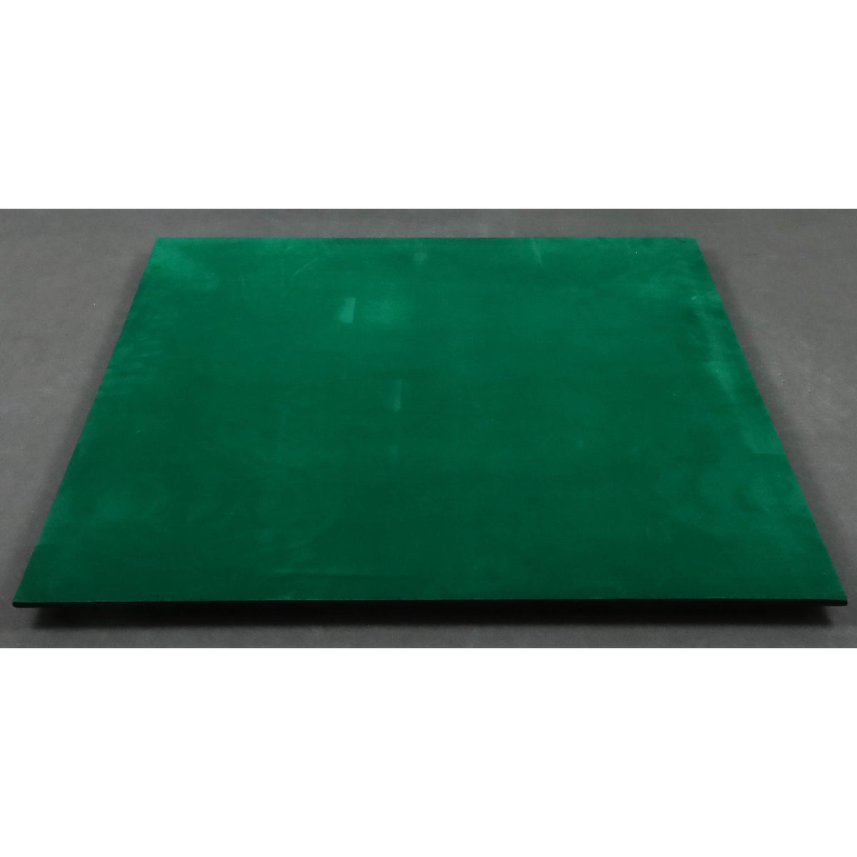 The complete protective green felt backing on the underside of a large ebony wood chessboard.
