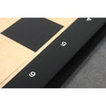 Macro shot of the screen-printed algebraic coordinates on the matte black ebony border of a luxury chess board.