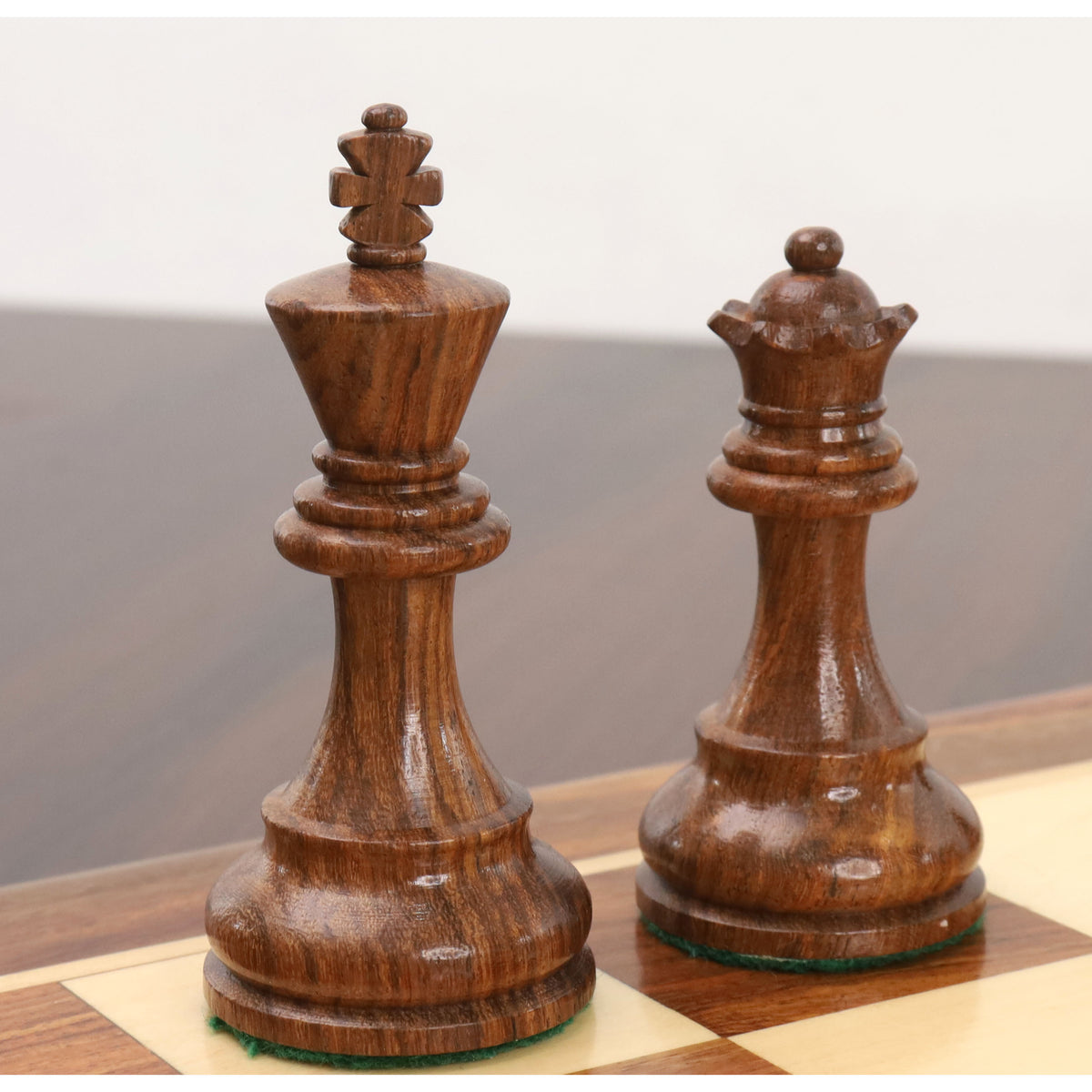 Close-up of golden rosewood king and queen from the Reykjavik Series Staunton chess set on a board.