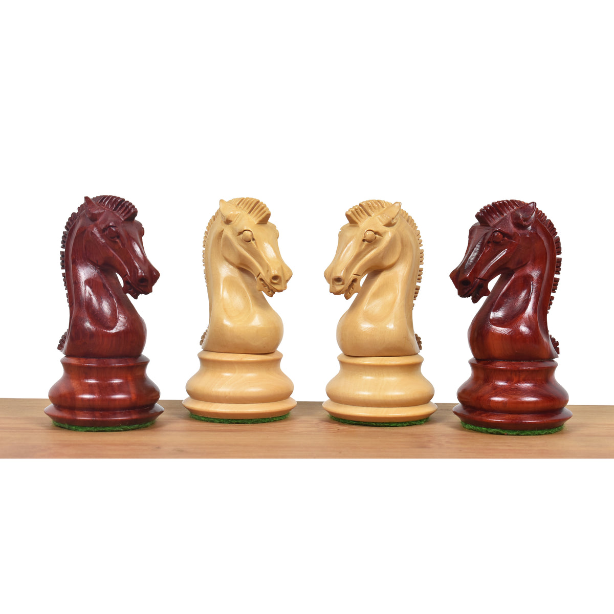 Profile view of four carved 3.9" Craftsman Staunton knights in Bud Rosewood and Boxwood facing each other.