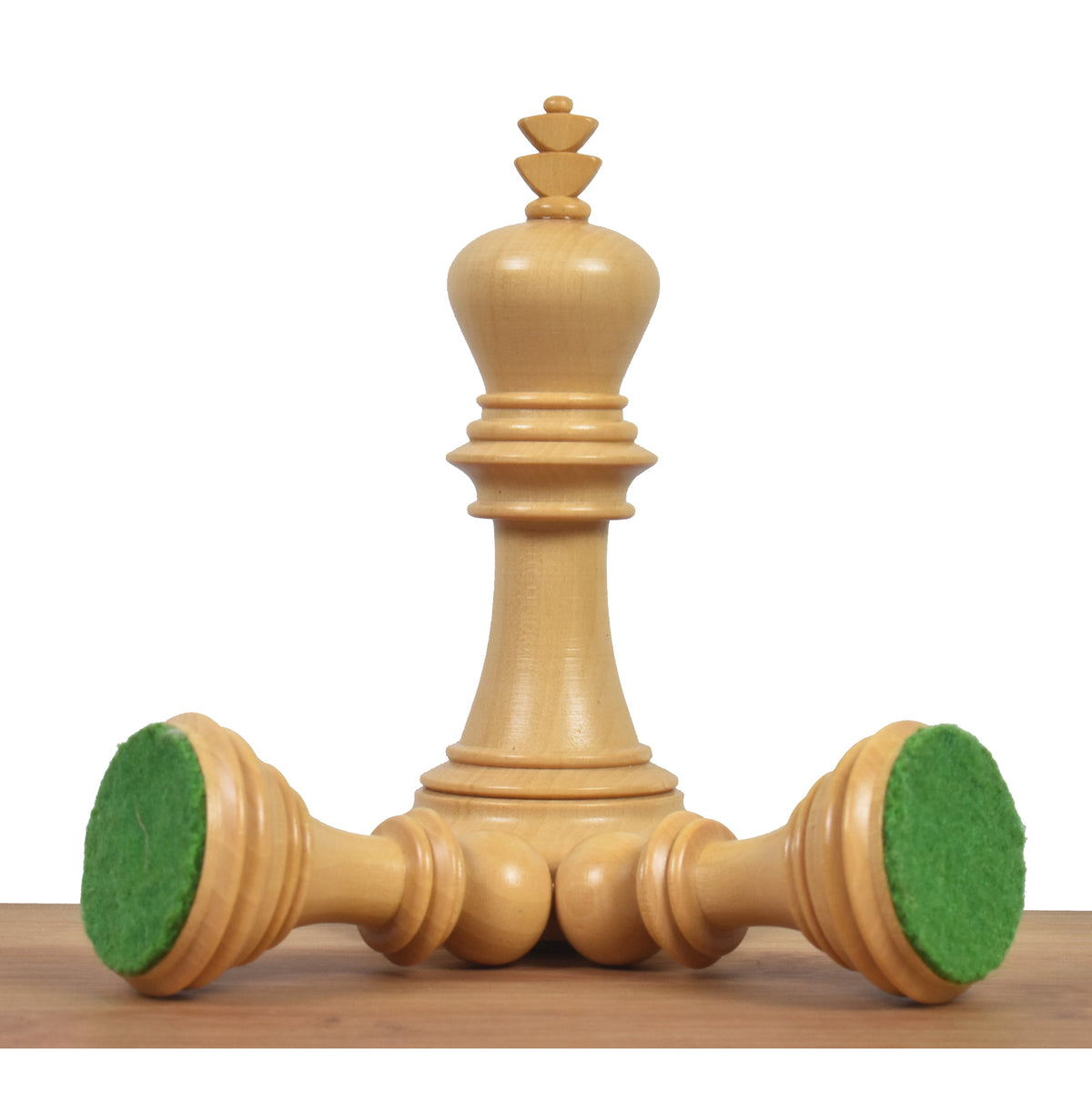 Boxwood Imperial Staunton king standing next to two fallen pieces revealing green felt bases.