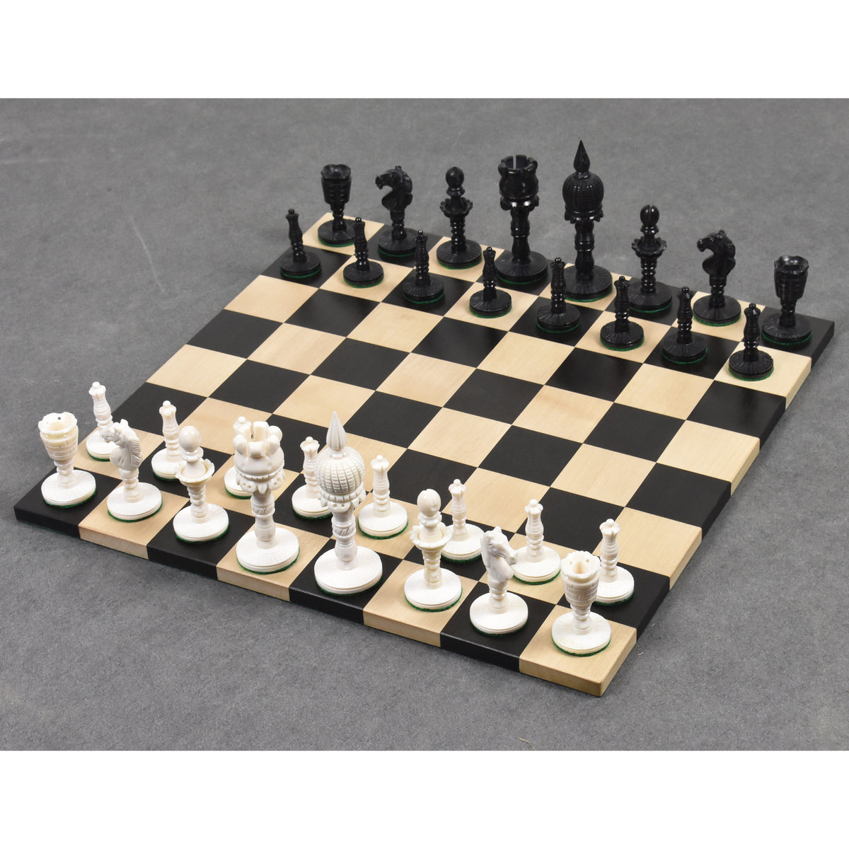Full set of English pre-Staunton camel bone chess pieces arranged on a wooden board.