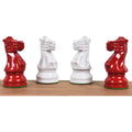 Close-up of two red and two ivory white painted Staunton knight pieces facing each other on a wood base.