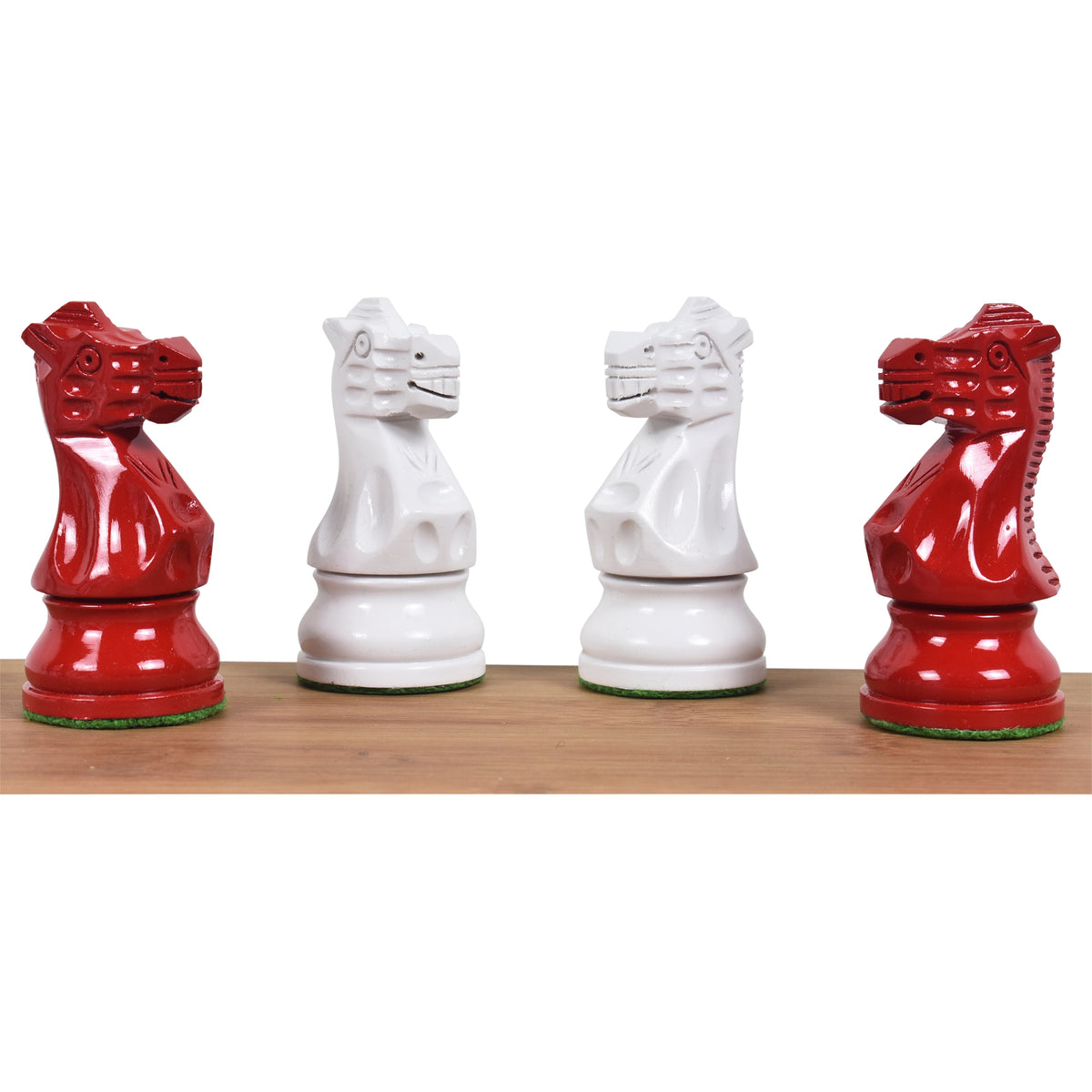 Close-up of two red and two ivory white painted Staunton knight pieces facing each other on a wood base.