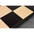 Close-up of alternating light and dark squares on a wooden chessboard.