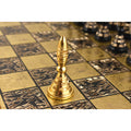 Single gold solid brass pawn piece standing on an engraved metal chess board square.