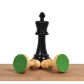 Triple weighted ebony king standing behind boxwood pieces displaying thick green felted bases.