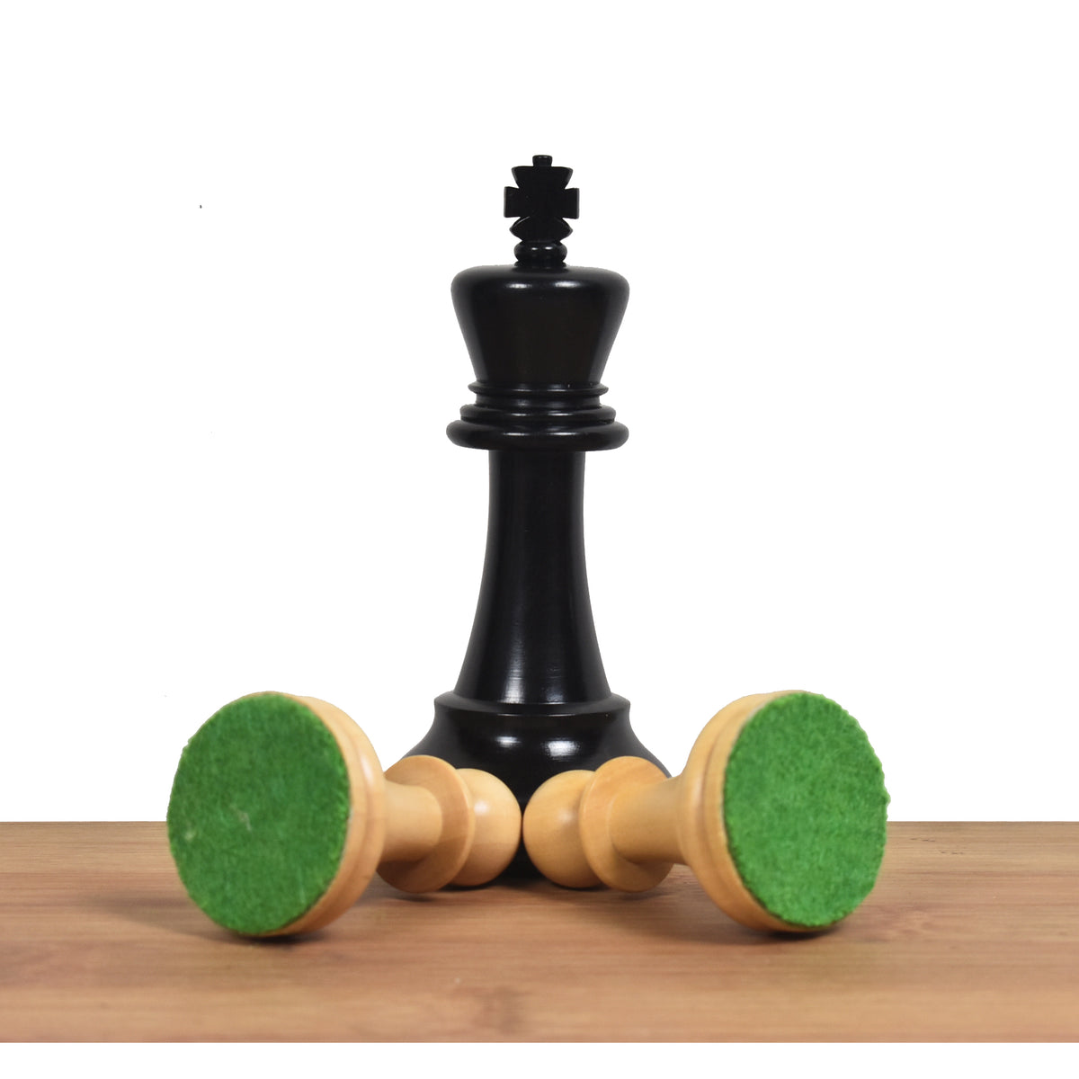 Triple weighted ebony king standing behind boxwood pieces displaying thick green felted bases.