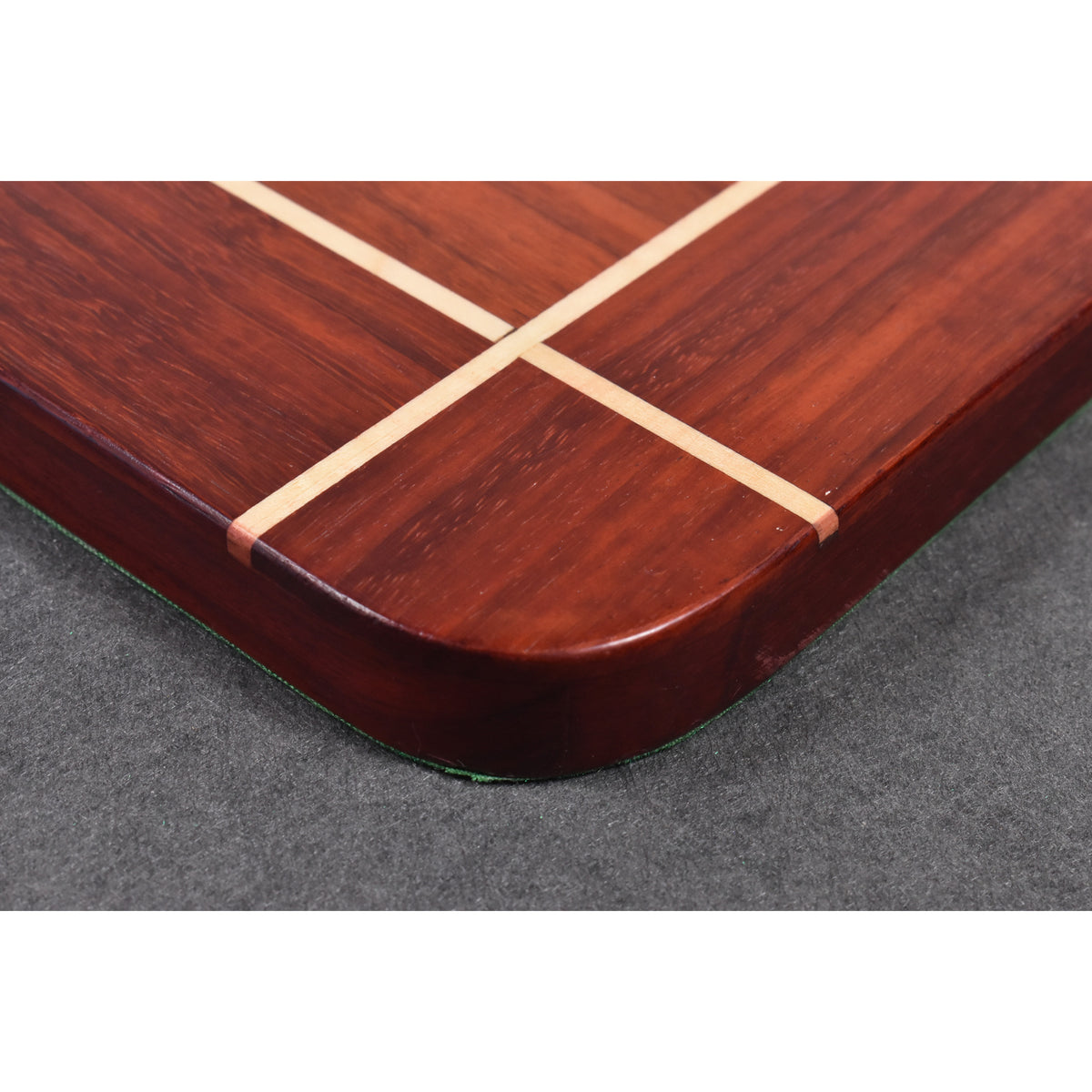 Close-up of the dark rosewood border and craftsmanship on a luxury wooden chessboard.