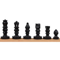 Lineup of handcarved black soapstone chess pieces displaying the full set of figures.