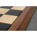 Extreme close-up of the natural wood grain and mitered border of the Ebony and Maple chess board.