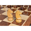 Detailed view of two hand-carved boxwood Knights on a glossy golden rosewood and maple chess board.