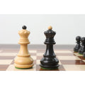 Ebonised and natural boxwood queens from the Zagreb collection displayed on a premium chess board.