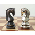 Profile view of antique and silver brass metal luxury chess knights facing each other on a board.