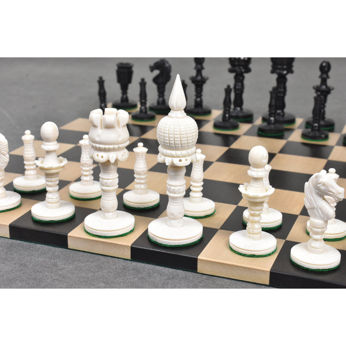 Close-up of the white King, Queen, and Rook camel bone pre-Staunton chess pieces.