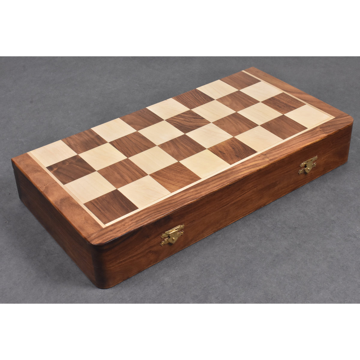 Closed folding wooden travel chess board made of golden rosewood with sturdy brass clasps for portability.