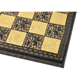 Close-up texture view of the engraved Warli tribal artwork on a black and gold metal chess board.