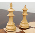 Close-up of the light boxwood King and Queen from the British Staunton chess set on a wooden board.