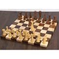 Light boxwood pieces from the Minimalist Tower Series chess set placed on a wooden board, with the king advanced forward.