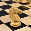 Detailed close-up of a carved boxwood knight from the Alban Staunton chess set on an ebony and maple chessboard.