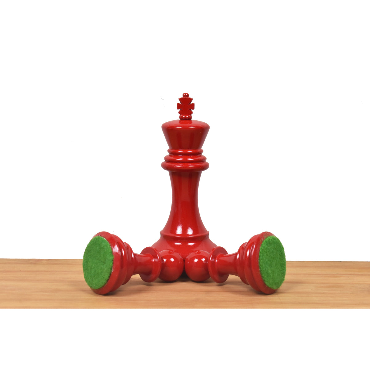 Red Staunton King piece showing the green felt base detail.