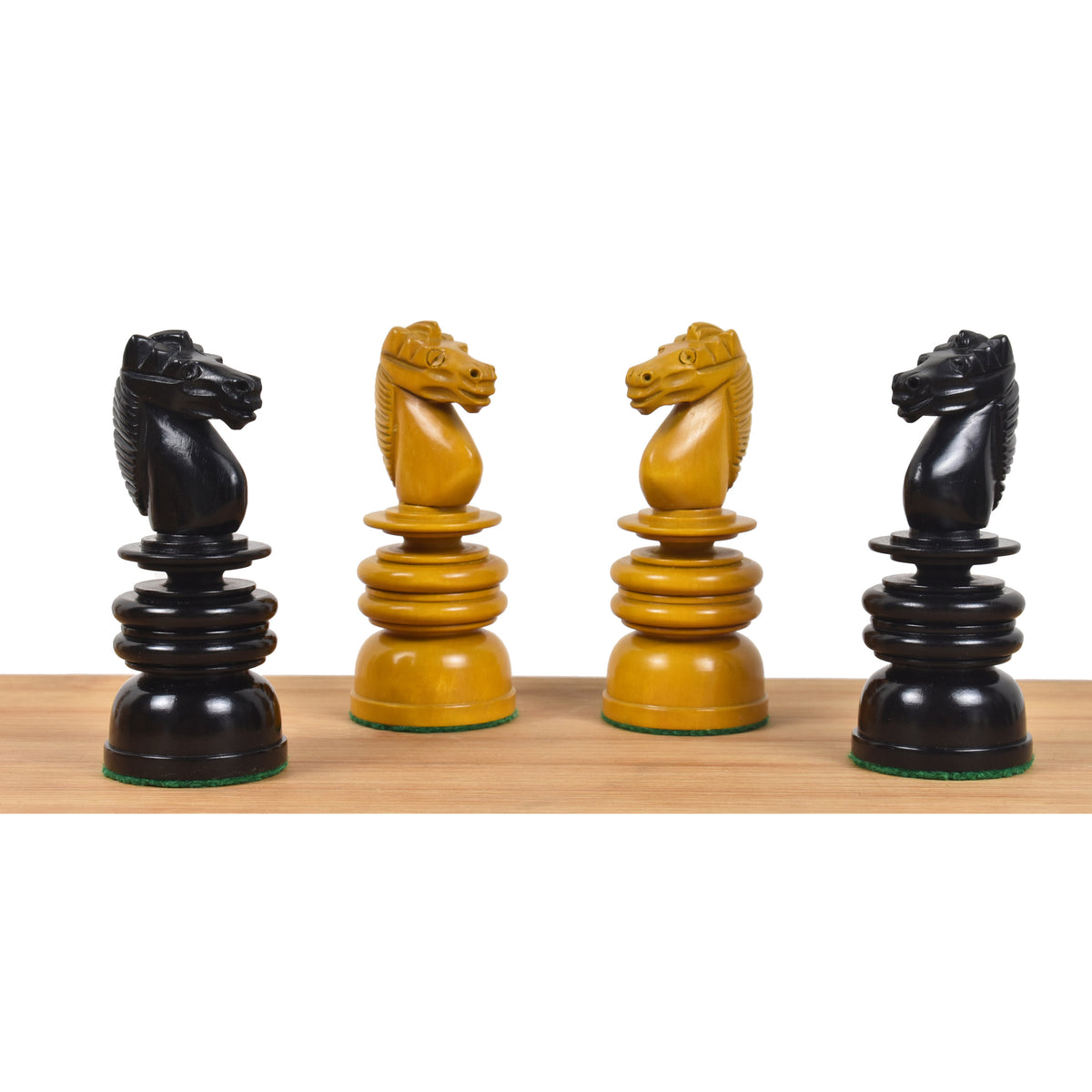 Detailed profile view of four carved ebony and antiqued boxwood Calvert style chess knights.