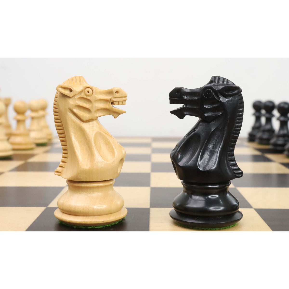 White and black knights from the 3.7" British Staunton weighted chess set facing off on a chessboard.