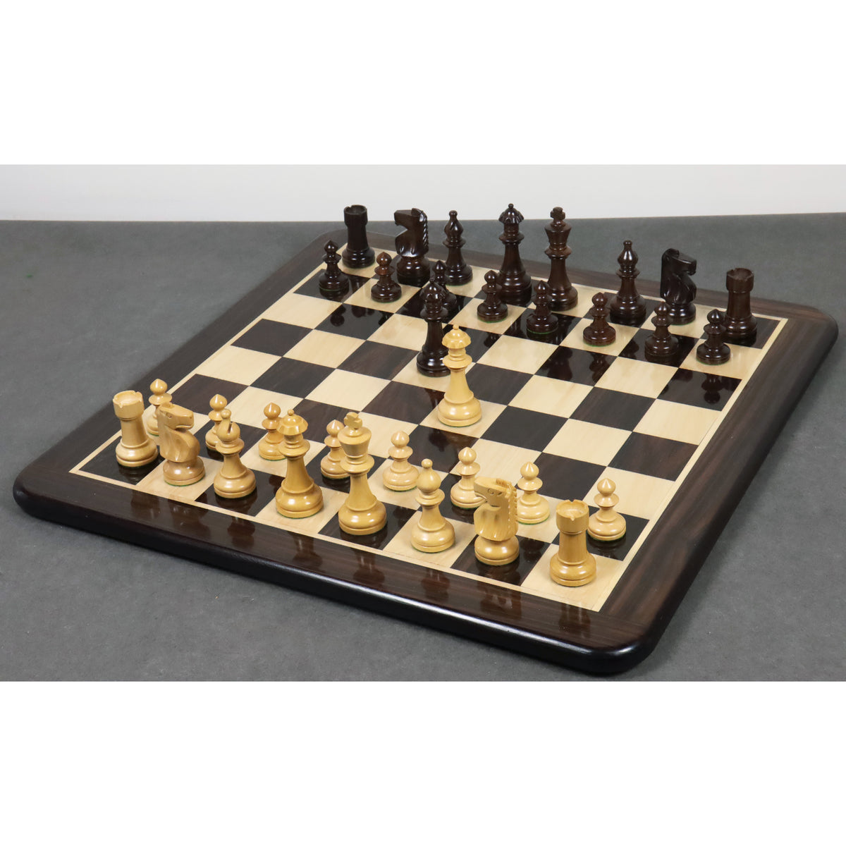 Complete Pinney Staunton chess pieces in rosewood and boxwood set up on a luxury wooden board.