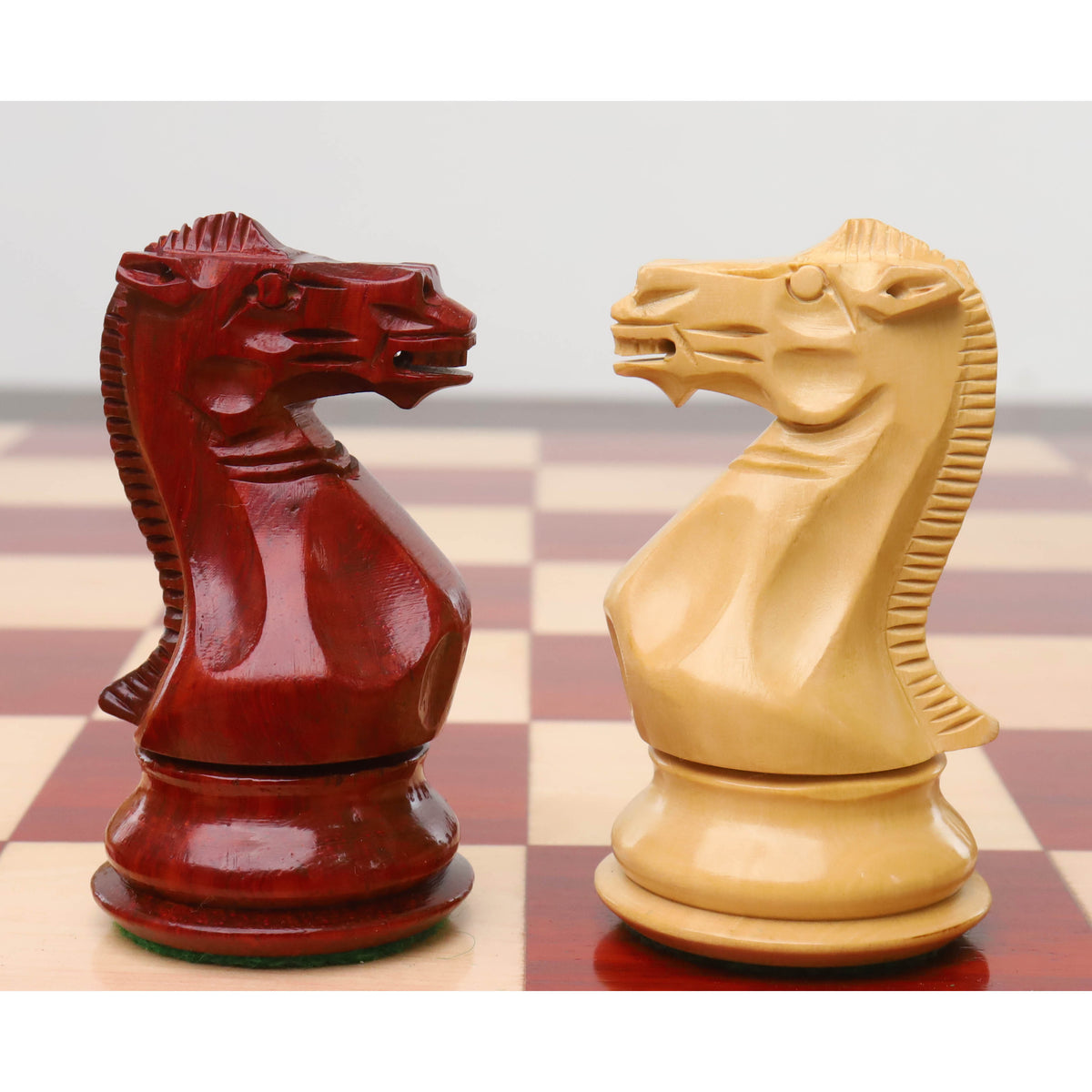 Close-up of meticulously carved boxwood and bud rosewood knights from the sleek Staunton chess set.