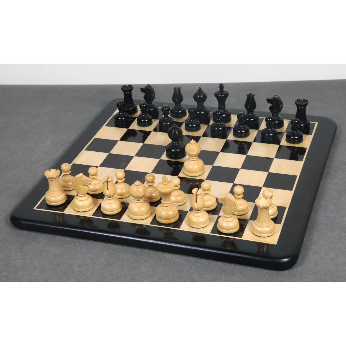 3.1 inch Library Series Staunton chess pieces arranged on a luxury black and maple wooden board.