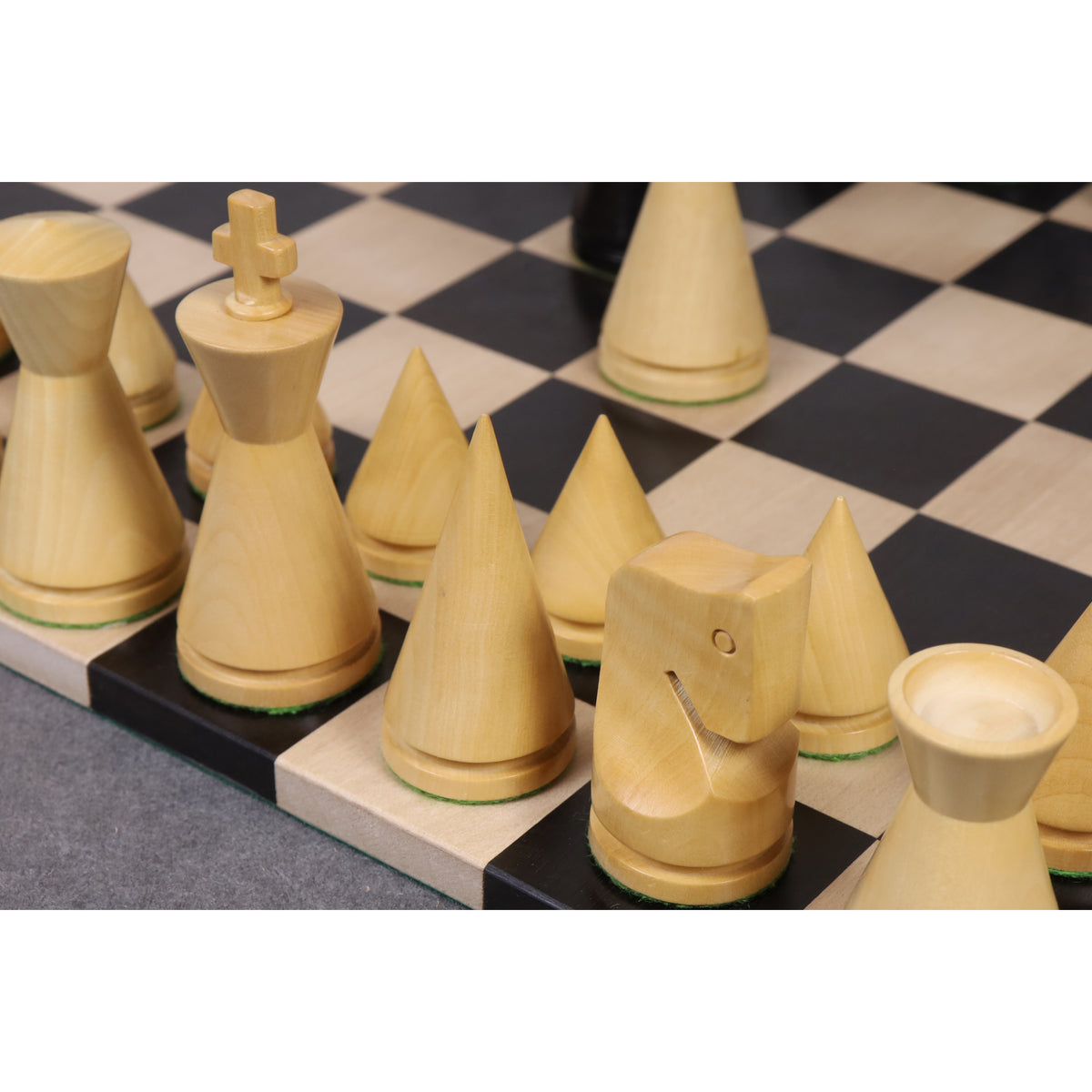 Detailed side view of boxwood minimalist chess pieces showing the unique Russian Poni conical design.