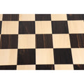 Overhead view of 57mm square ebony and maple wood chess board squares.
