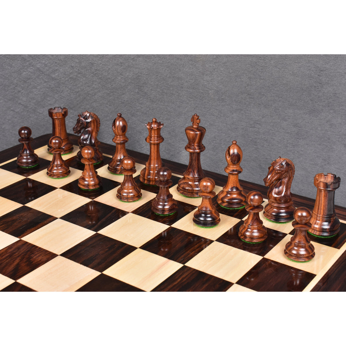 Dark rosewood 3.9" Craftsman Staunton chess pieces arranged in starting rows on a glossy wooden chessboard.