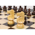Two hand-carved boxwood knights from the Pinney Staunton set arranged on a polished chessboard.