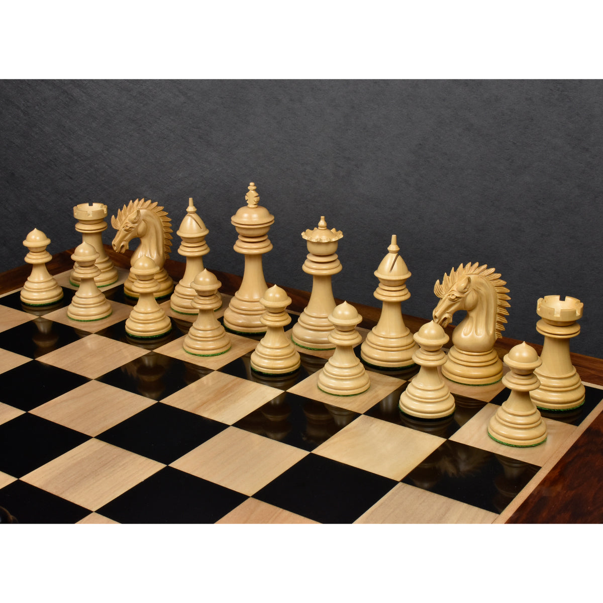 Fine natural boxwood chess pieces set up cleanly on a glossy wooden board with a rich dark wood border.