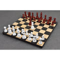 Burgundy and white lacquered boxwood Prime Staunton chess pieces fully set up for a game on a wooden chessboard.