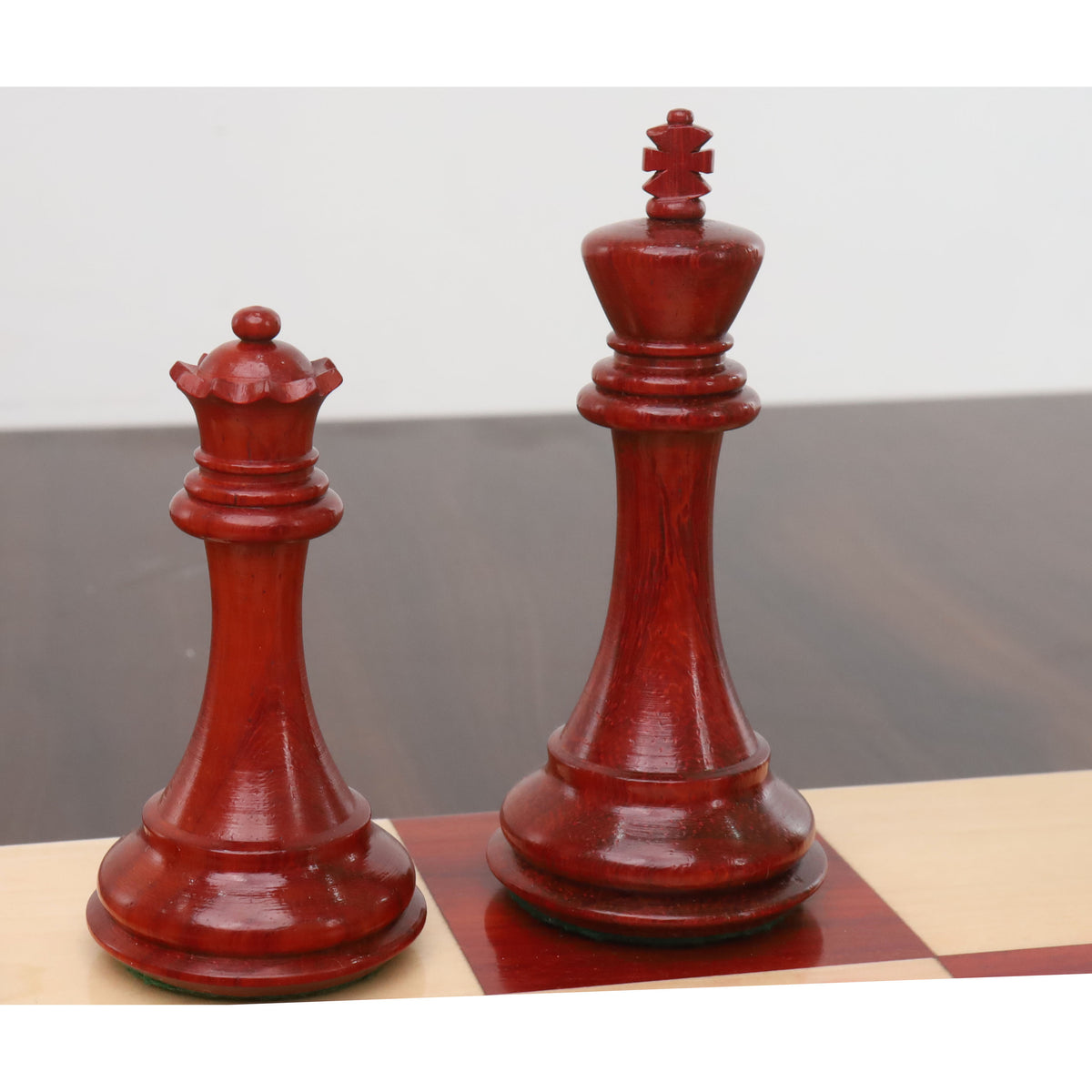 Detailed view of the crimson bud rosewood king and queen from the sleek Staunton luxury chess pieces.