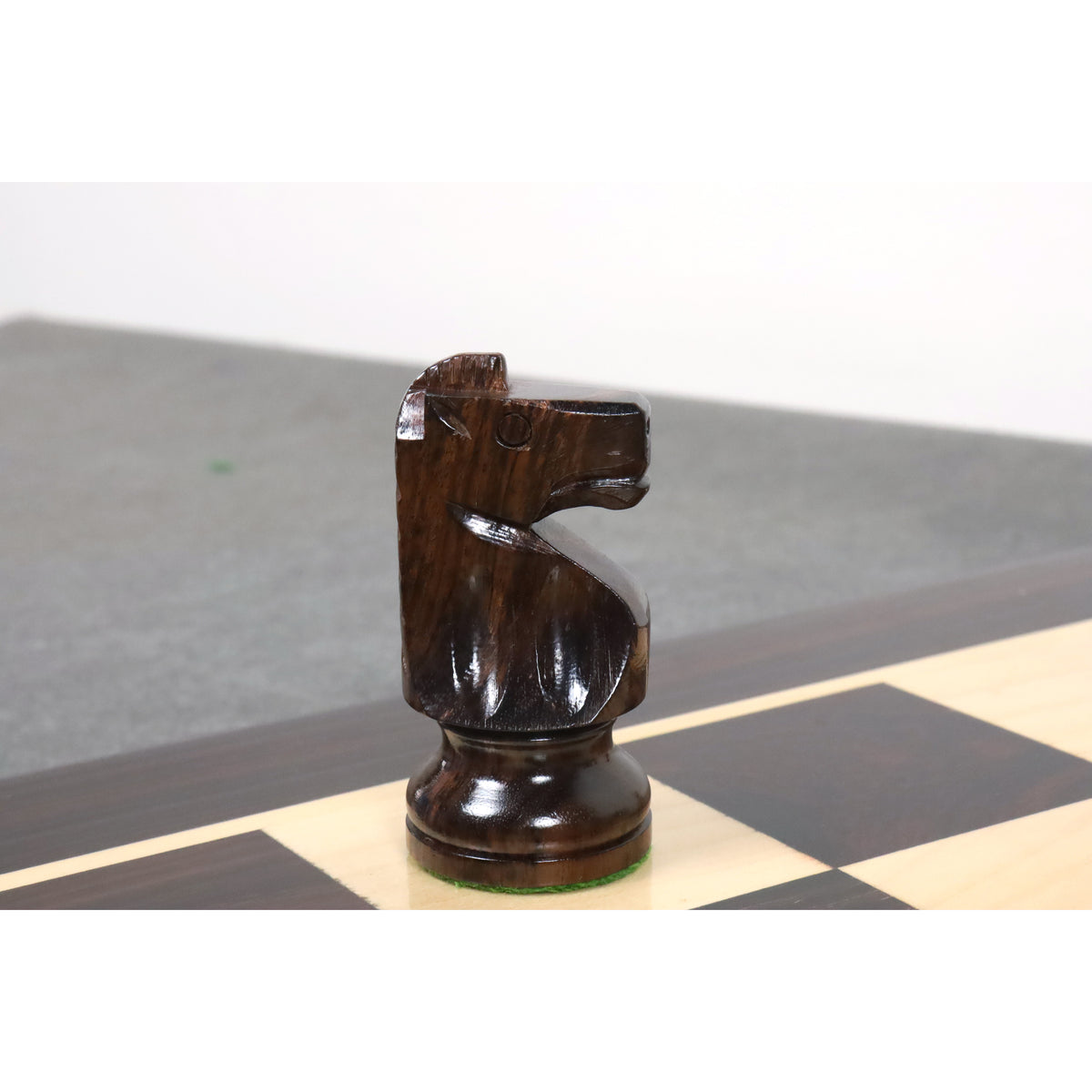 Profile view of a finely crafted dark Anjan rosewood knight from the Pinney Staunton chess set.
