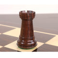 Close-up of a triple weighted rosewood rook from the sleek Staunton set resting on a glossy chessboard square.