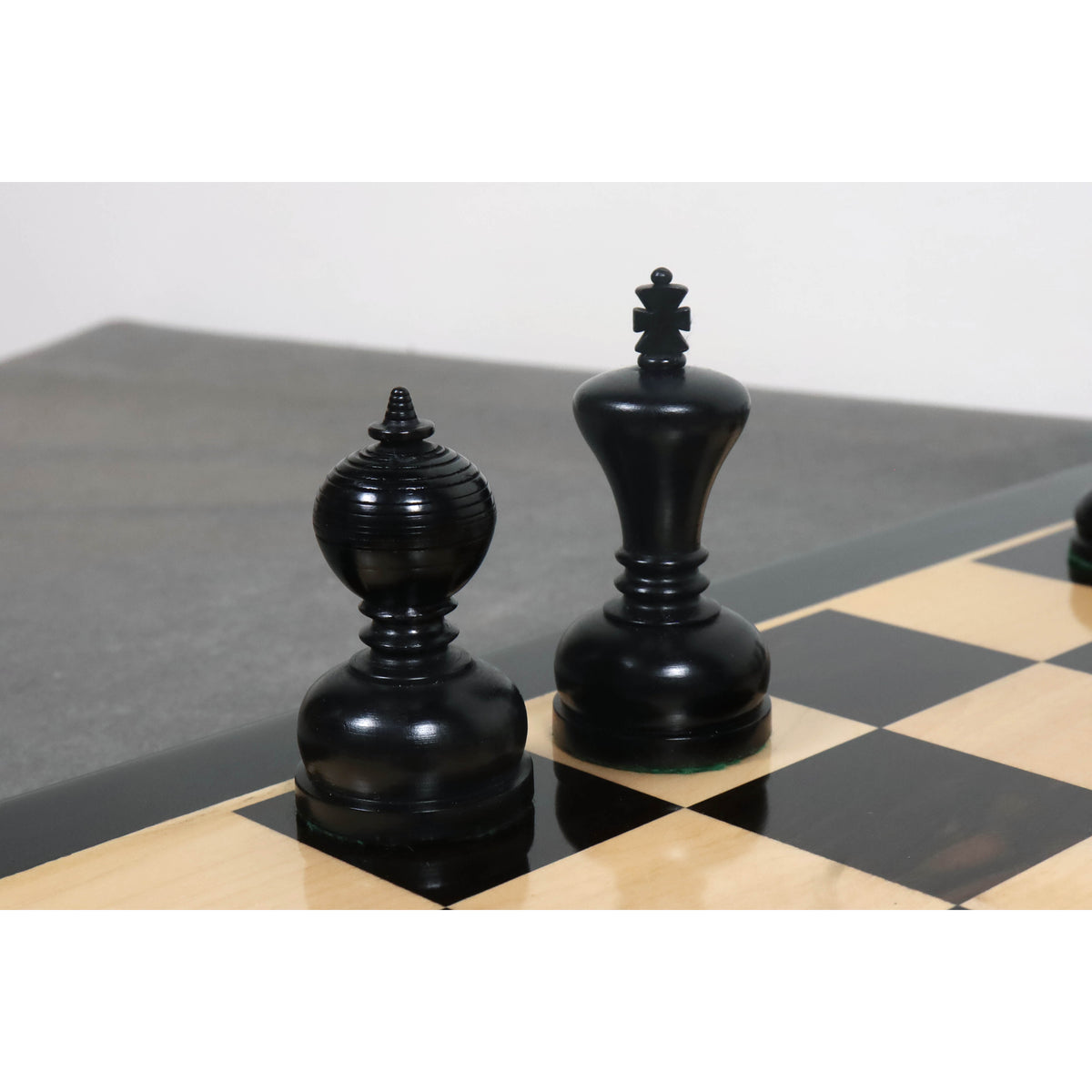 Black ebonised King and Queen pieces from the Library Series showing fine wood grain and polish.