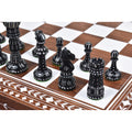 Hand-carved black camel bone chess pieces on an inlaid wooden board.