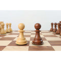 A natural boxwood and a Golden Rosewood Pro Staunton pawn standing side-by-side.