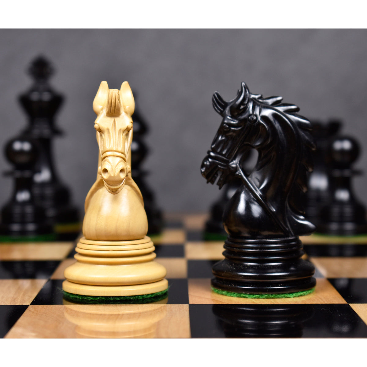 Detailed close-up of handcrafted ebony and boxwood knights from the Napoleon luxury chess set.