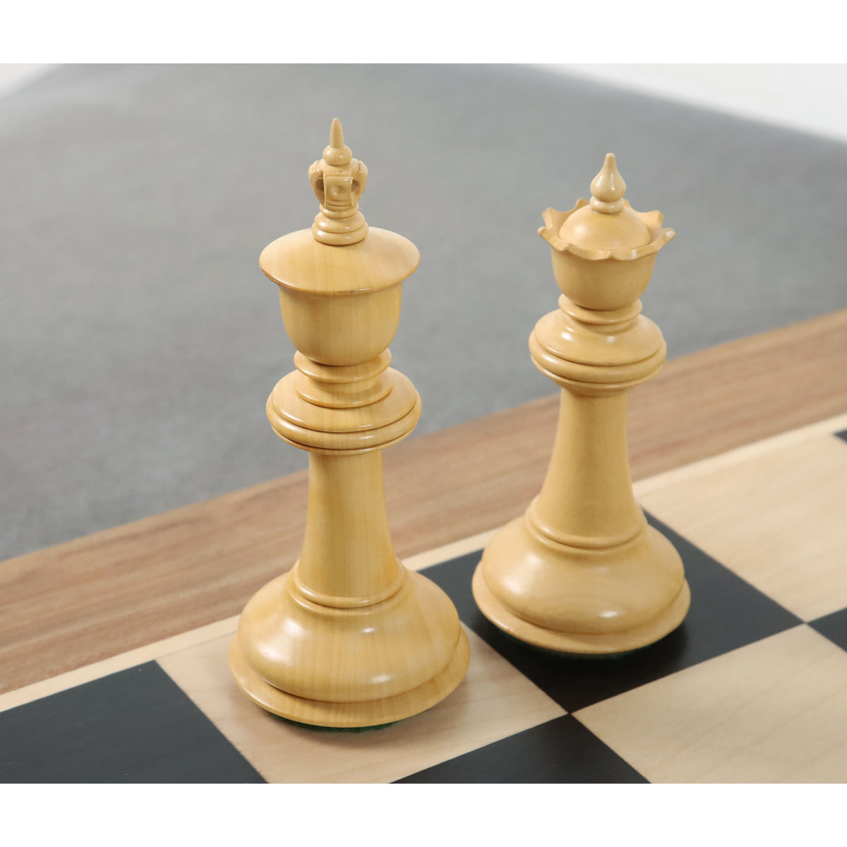 Elegant 4.6-inch boxwood king and queen chess pieces on a wooden board.