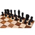 Side angle view of the complete ebonised boxwood side of Berliner modern minimalist chess pieces on a board.