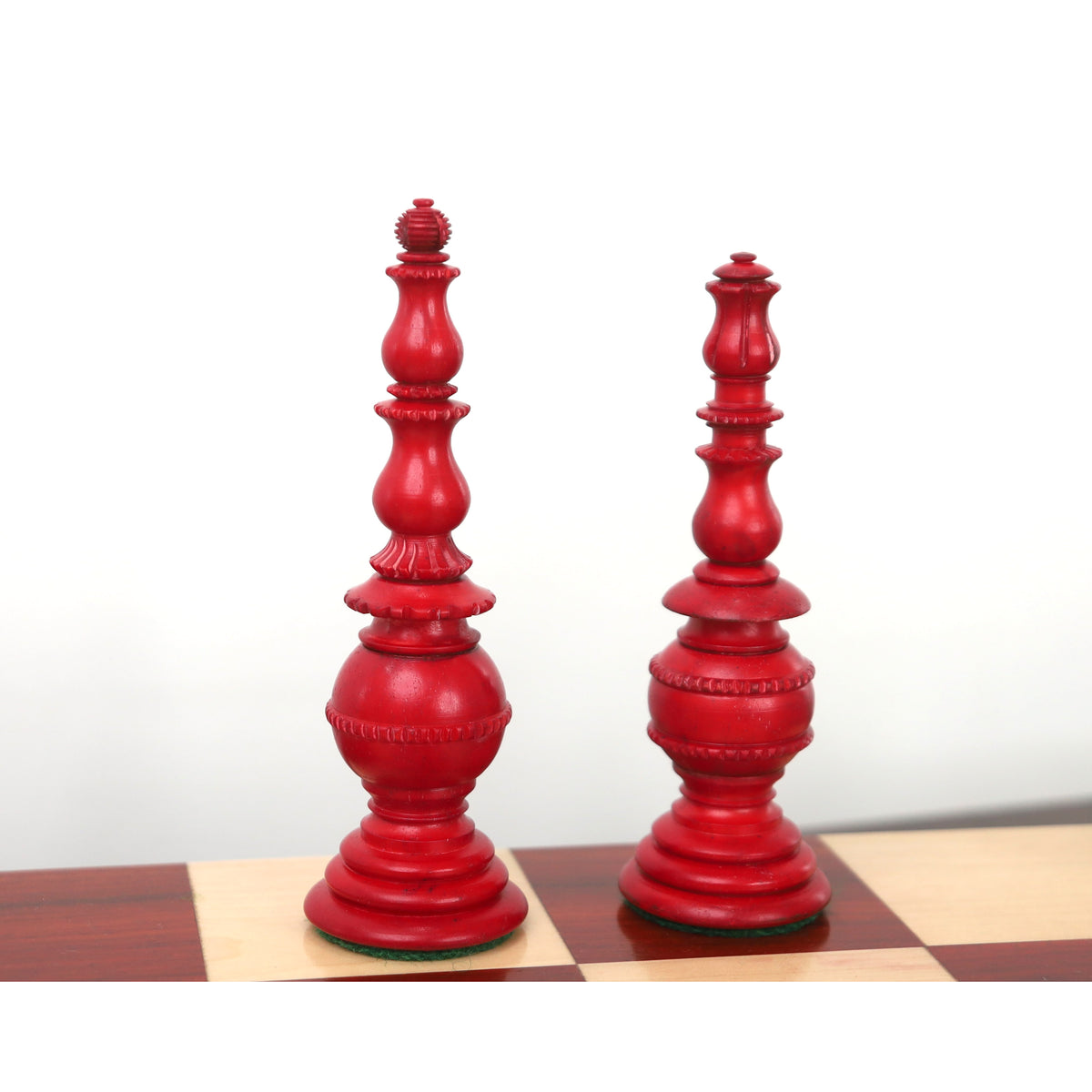 Pair of crimson Turkish Tower pre-Staunton chess pieces on a board.